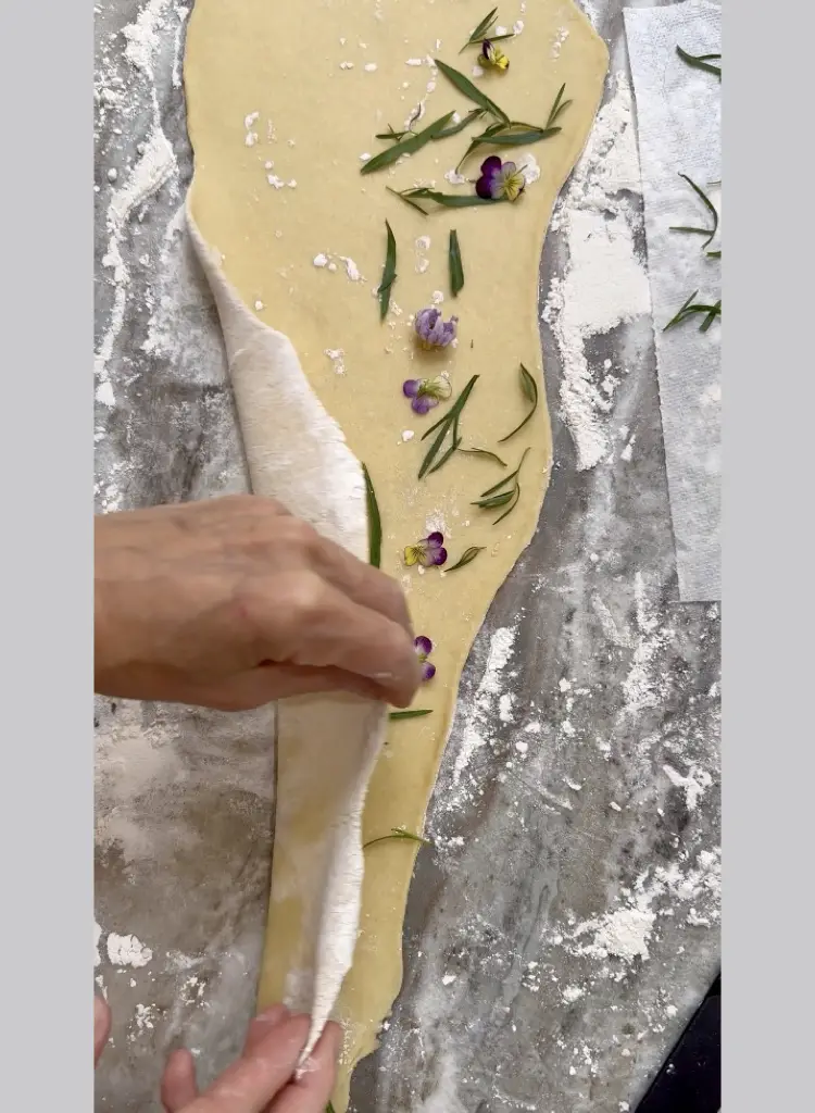 Folding Thin Sheets Of Dough With Herbs and Flowers Inside