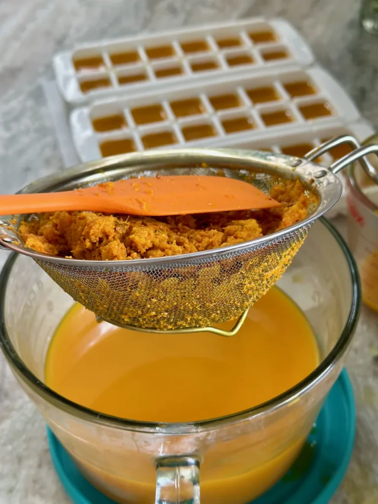 Straining The Golden Turmeric Shot Liquid Once It Has Steeped 24 Hours