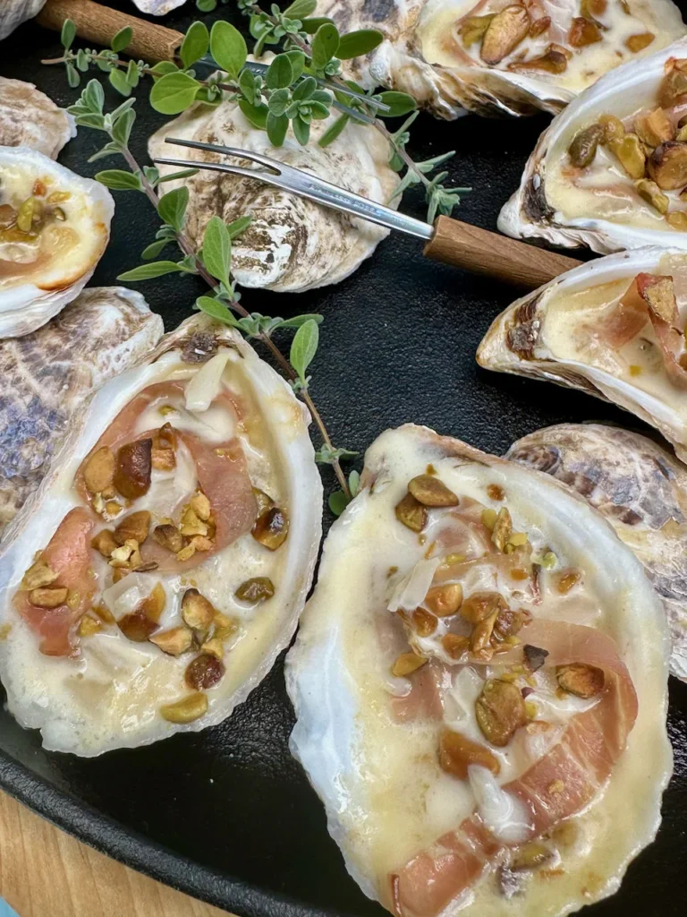 Toasted Pistachios and Prosciutto Over Roasted Oysters In Champagne Sauce