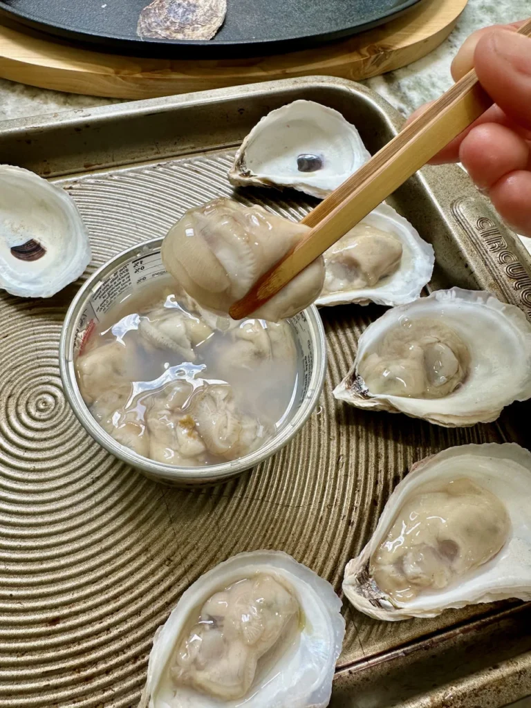 Raw Oysters Placed On Half Shells To Be Lightly Roasted