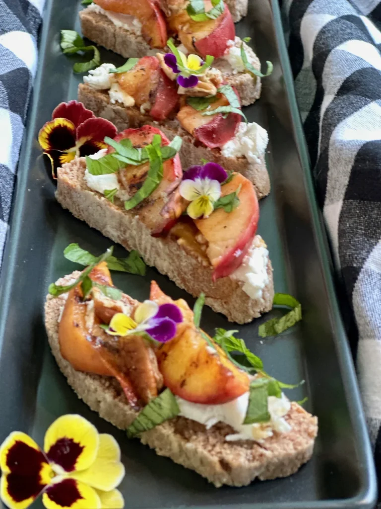 Grilled Peach Pecan Crostini with Honey and Edible Flowers